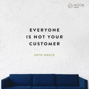 Quote on a white brick wall above a blue sofa: “Everyone is not your customer”, Seth Godin
